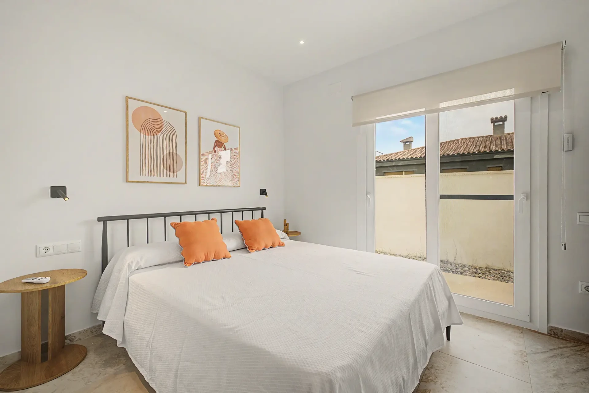 Habitació de matrimoni amb coixins taronja i quadres